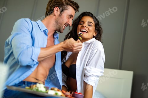 Preview: Portrait of happy sexy couple enjoying sensual moments together with food and wine