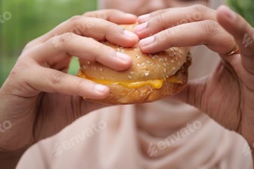 Preview: women hand holding beef burger top view