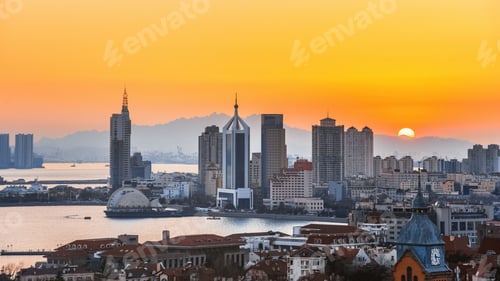 Preview: Bright orange sunset sky over the skyline of Qingdao, Shandong Province, China