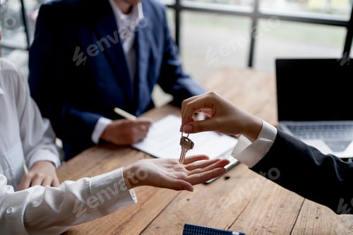 Preview: Real estate agent giving house key to the client after signing the real estate contract. Home and re