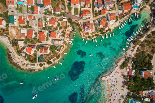 Preview: Coastal village with red-roofed houses, turquoise waters and boats along shore