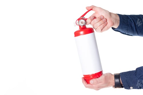 Preview: Man using fire extinguisher isolated on white
