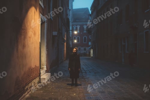 Preview: Portrait of young woman standing in street at dusk, Venice, Italy