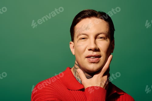 Preview: A young man with tattoos poses confidently against a vibrant green background