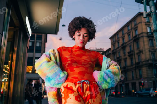 Preview: Proud young black woman posing outdoor city night strong and confident hands on hips