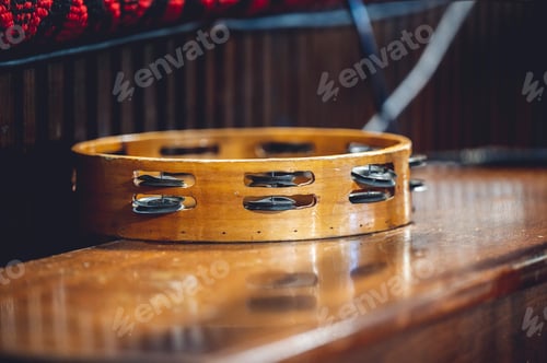 Preview: Closeup of a Tambourine instrument on a wooden table