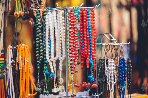 Preview: Closeup of multicolored rosary beads at a street market
