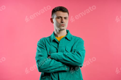 Preview: Annoyed Young Man Posing in Front of Pink