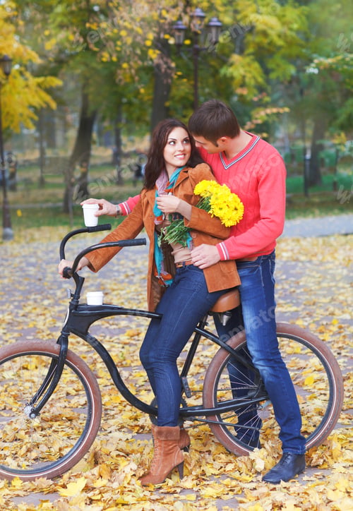 Preview: Happy couple with bicycle in autumn park