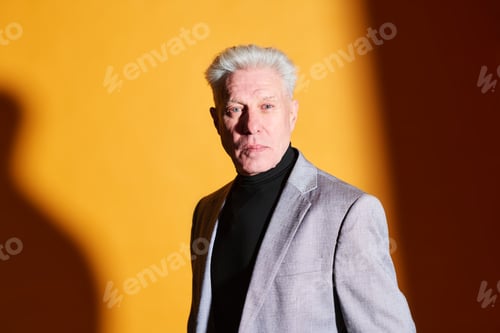 Preview: Serious mature businessman in grey blazer and black turtleneck