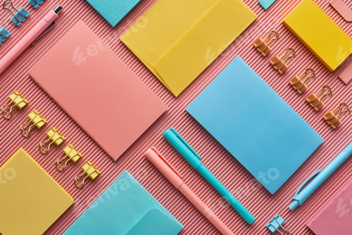 Preview: top view of colorful stationery supplies on pink