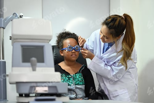 Preview: Ophthalmologist testing vision or sight of girl patient for glasses or treatment in a clinic.