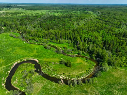 Preview: Meandering river through lush green fields and dense forest