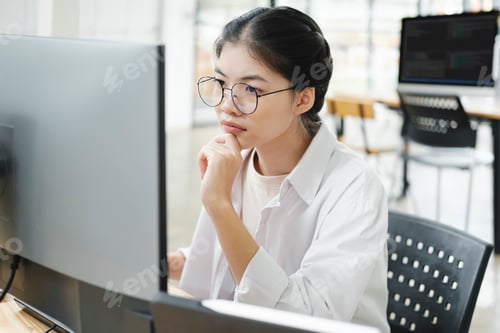Preview: Young programmer working on desktop PC in office of software company.