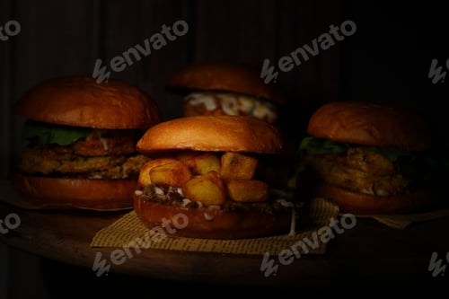 Preview: Classical burgers on wooden table with dark background