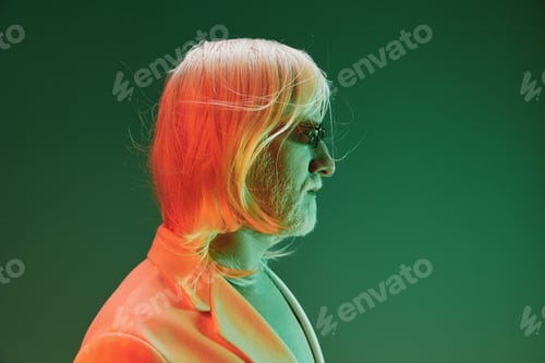 Preview: Portrait of a person with long light colored hair and beard, illuminated in green and orange