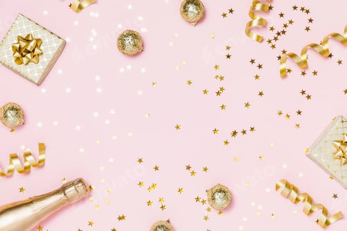 Preview: Christmas holiday flat lay. Gold party decoration, confetti, gifts, champagne on pink background.