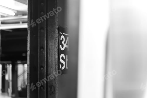 Preview: Grayscale shot of a signboard of a station in the subway