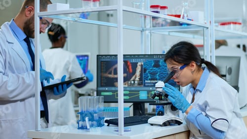 Preview: Scientist team analysing results using microscope