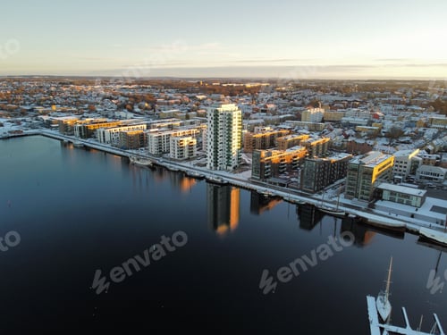Preview: Aerial of snowy Karlstad cityscape reflecting in the water, Sweden
