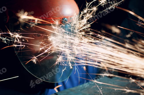 Preview: Man worker in transparent protective mask works on metal with circular grinder saw. Sparks and face.