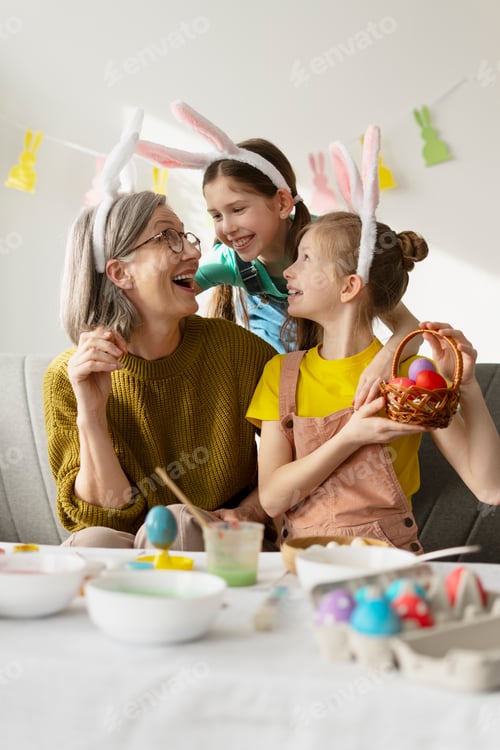 Preview: Grandmother and Granddaughters Painting Easter Eggs Together at Home