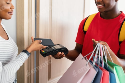 Preview: Black Lady Paying Courier Putting Phone To Payment Terminal Indoor
