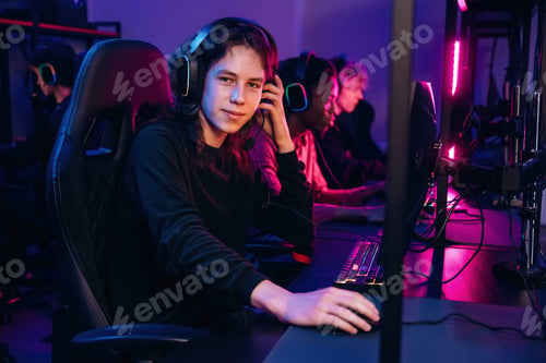 Preview: Dude with long hair is sitting. Gamers are playing video game by computers