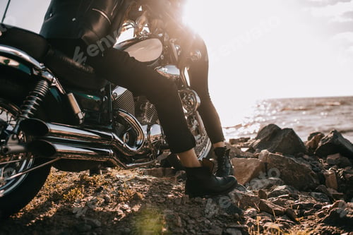 Preview: cropped view of couple on chopper motorbike near sea with sunlight