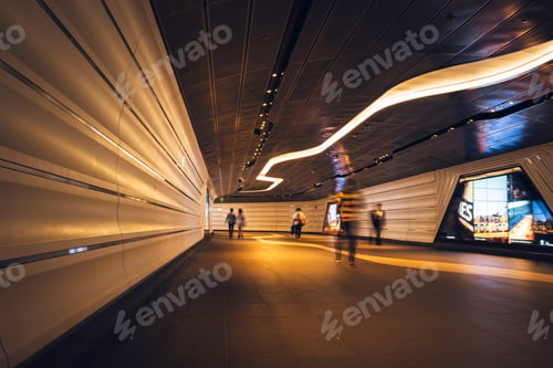 Preview: Commuters walking through a futuristic looking pedestrian tunnel featuring an LED integrated lights