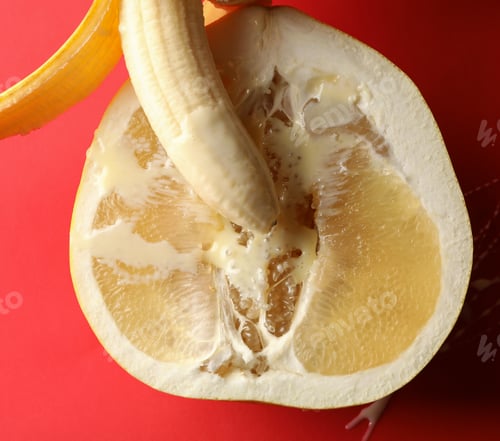 Preview: Banana with condensed milk on pomelo fruit on red background