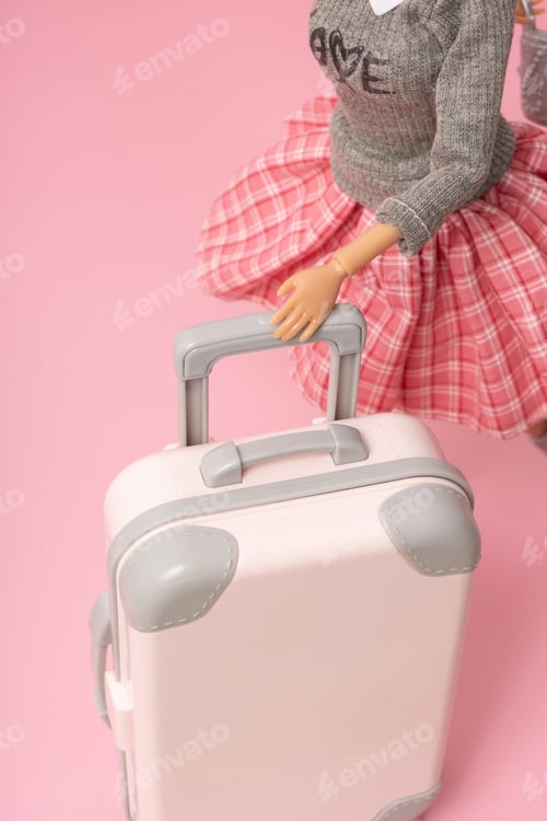 Preview: The doll carries a suitcase on wheels. Travel, vacation creative minimalistic concept