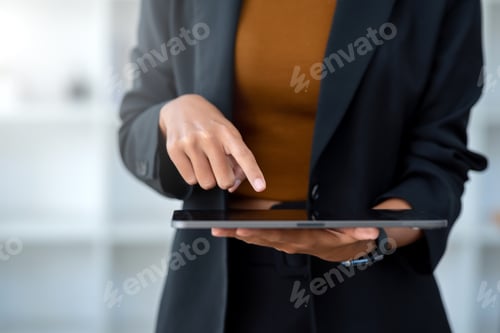 Preview: Closeup image of female using digital tablet to send text , work or play social media in office.