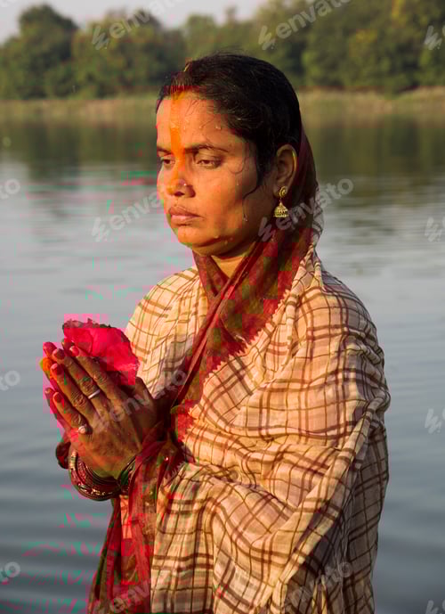 Preview: Traditionally dressed Indian woman pray into the river on Chhat Puja Festival.