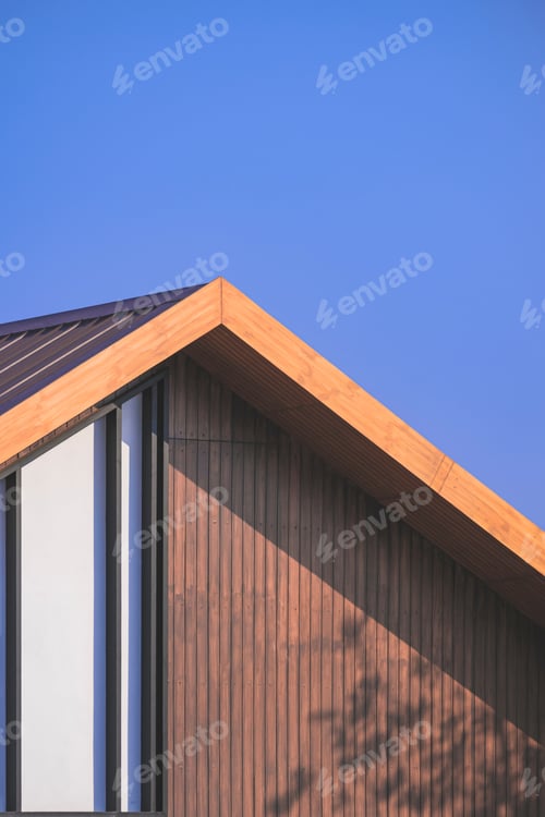 Preview: light and shadow on surface of vintage wooden gable roof with battens decoration against blue sky