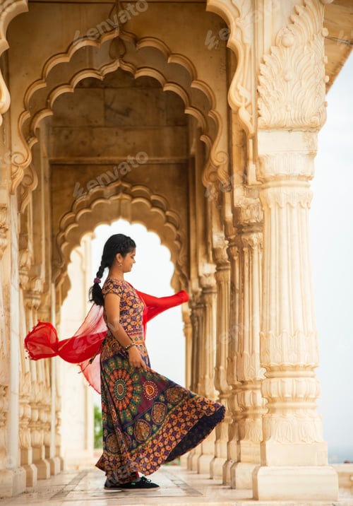 Preview: Young female tourist dancing between arches and Pillars.