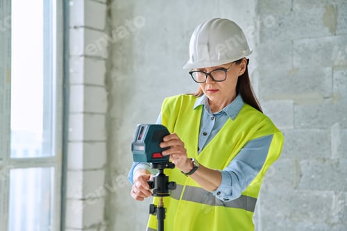 Preview: Woman industrial worker in protective vest helmet working on construction site