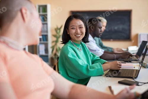 Preview: Young cheerful Asian woman looking at her classmate or coworker