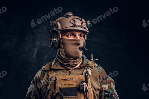 Preview: Close-up portrait. Private security service contractor in camouflage helmet with walkie-talkie.