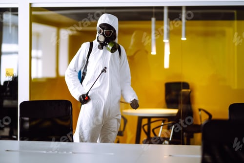 Preview: Disinfecting of office to prevent COVID-19, Man in protective hazmat suit with spray chemicals.