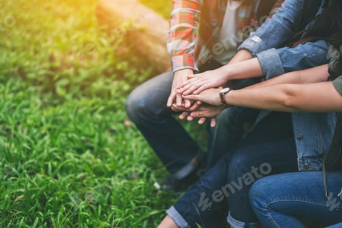 Preview: Closeup image of people putting their hands together in the outdoors