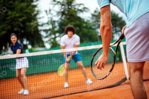 Preview: Tennis sport people concept. Mixed doubles player hitting tennis ball with partner standing near net