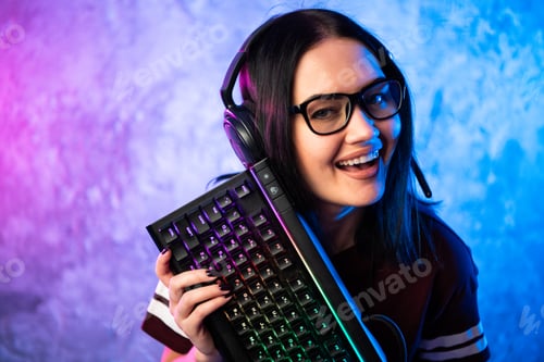 Preview: Gamer girl playing with computer at home. Young female posing with computer keyboard