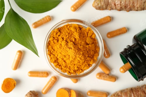 Preview: Turmeric capsules, powder, roots and green leaves on white background, flat lay
