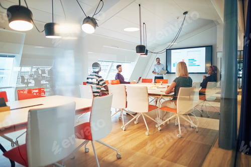 Preview: Manager and staff discussing graphs together during a boardroom meeting