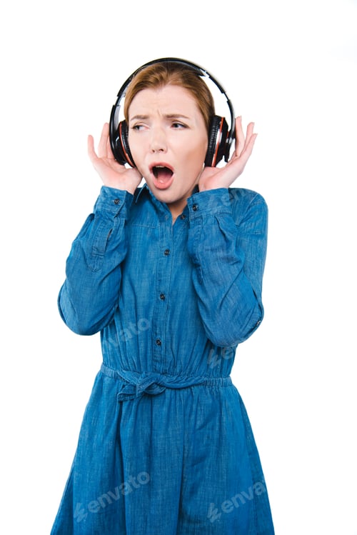 Preview: shocked stylish girl listening music with headphones, isolated on white
