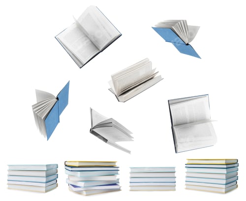 Preview: Books flying over stacks on white background