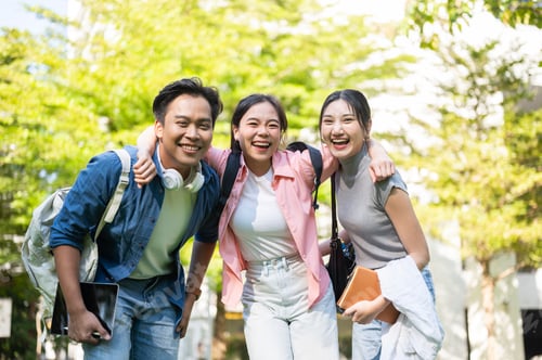 Preview: Happy asian man and woman student holding or hugging friends shoulder while standing in a university