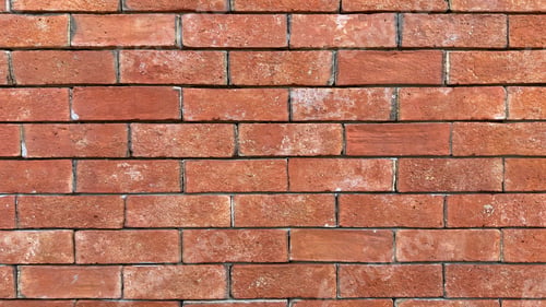 Preview: A brick wall with a few cracks and some dirt on it.