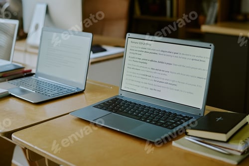 Preview: Pair of Laptops Displaying Text in Modern Workspace